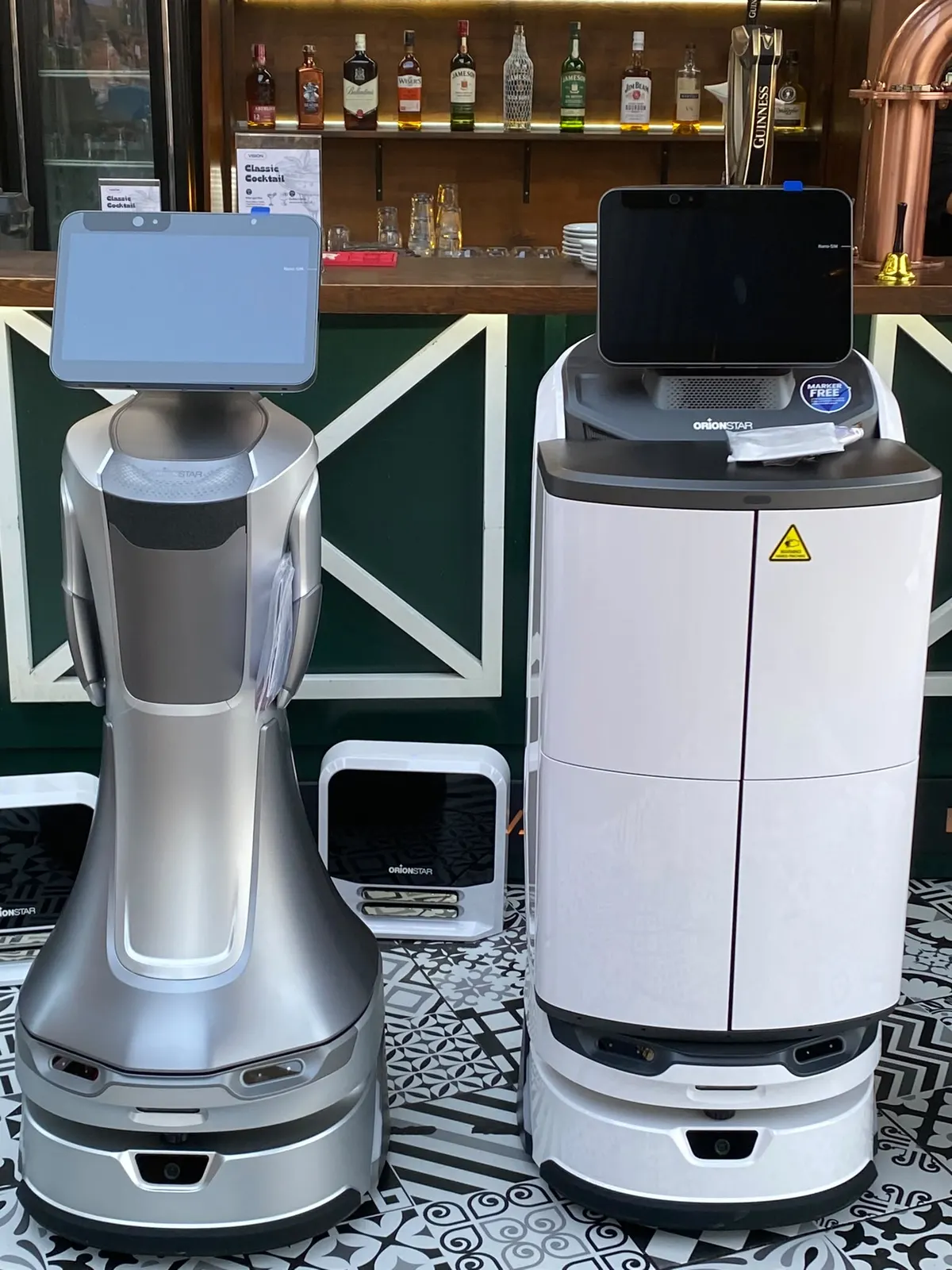 GreetingBot Nova ve LuckiBot Pro Autodoor bar tezgâhı önünde